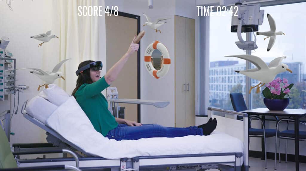 Patient in een ziekenhuis bed test Holomoves bril en ziet hologram vogels
