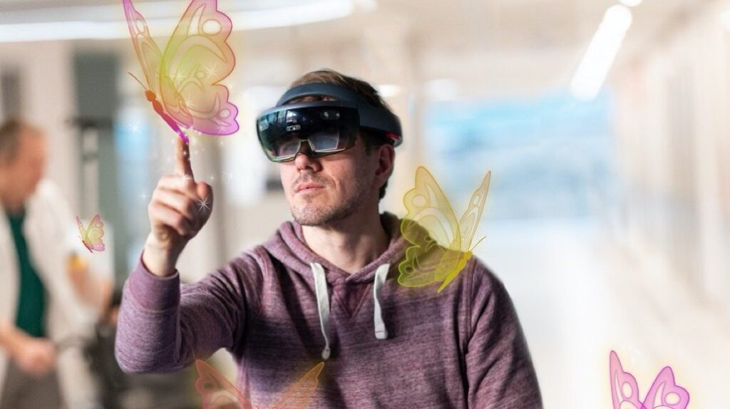 Bril van Holomoves wordt getest door een jongen, hologrammen van vlinders zijn zichtbaar