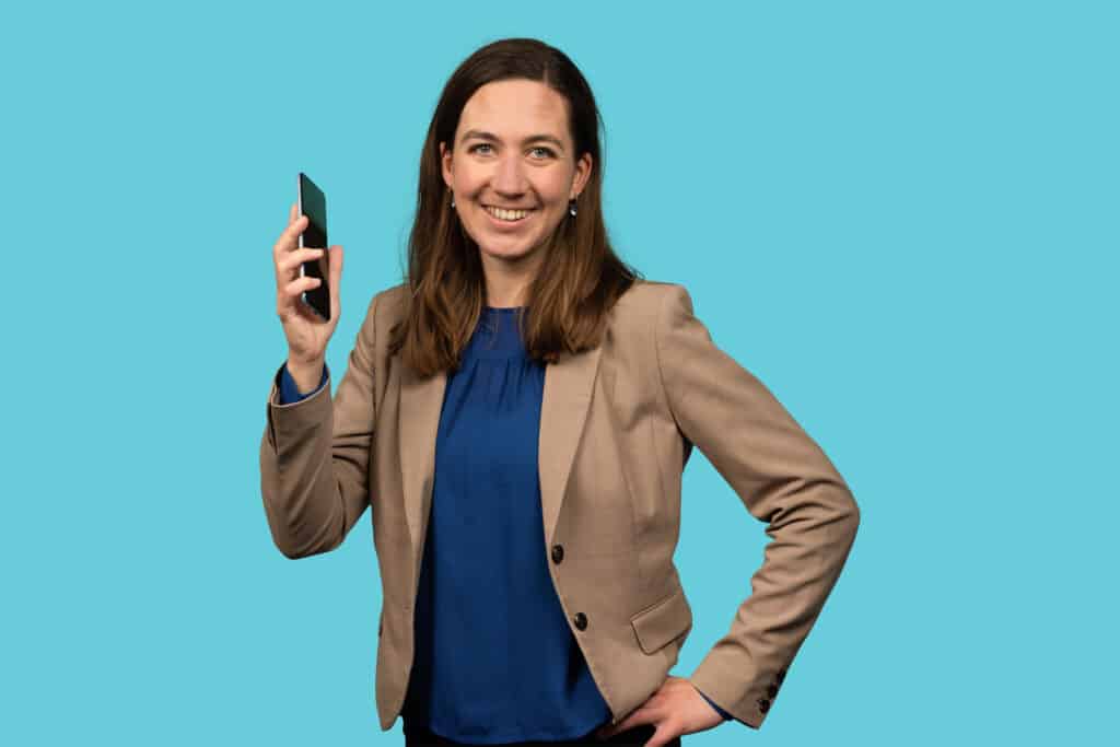 Medewerker ROM Utrecht met mobiel in de hand.