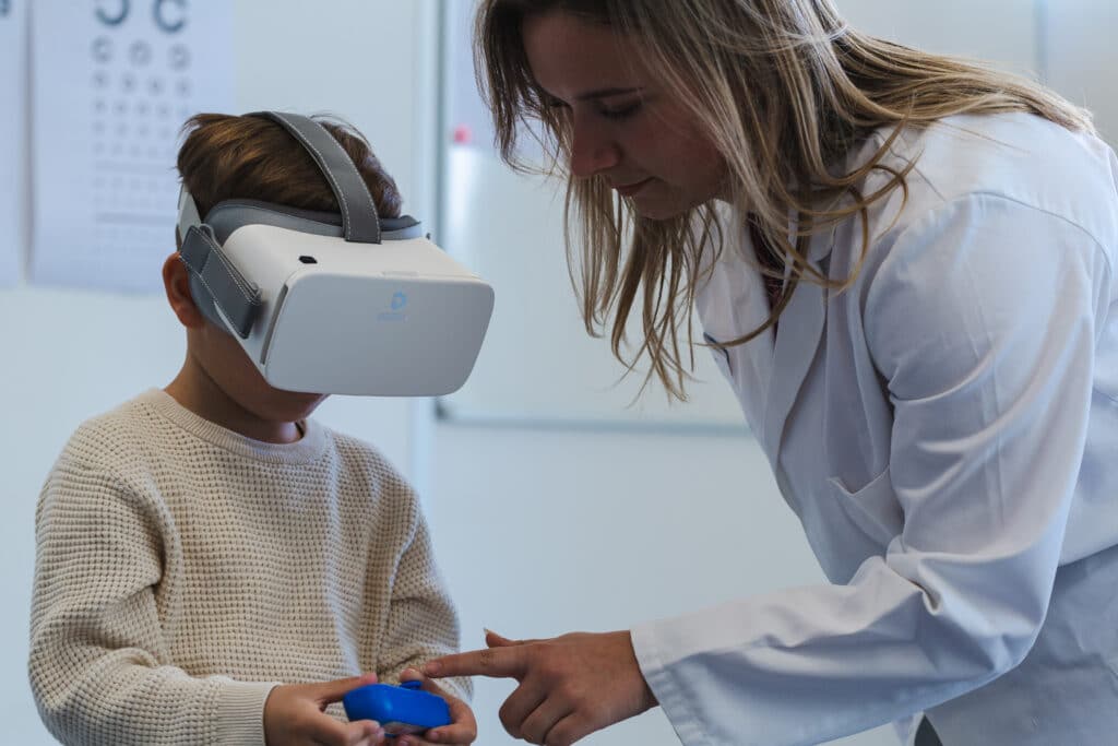 Zorgmedewerker legt gebruik van VR bril uit aan kind.